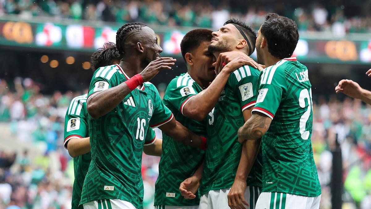 Raul Jimenez celebrating with teammates after scoring a goal at Mexico City Stadium.
