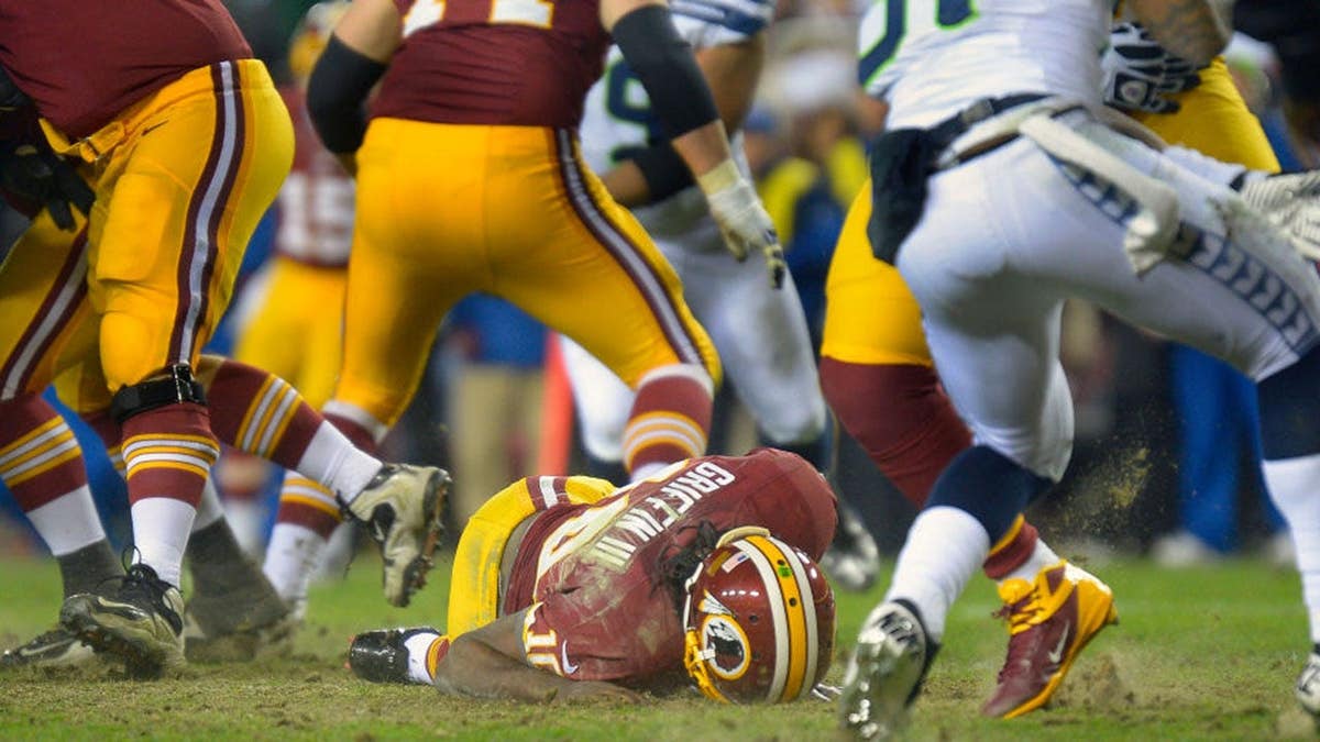 El quarterback de Washington, Robert III, tirado en el suelo tras lesionarse la rodilla derecha durante un partido.