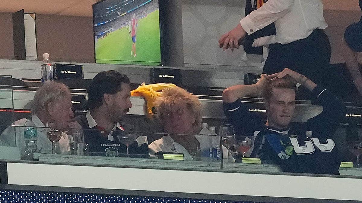 Sir Rod Stewart seated in the stands at Boston Stadium during a FIFA World Cup match.