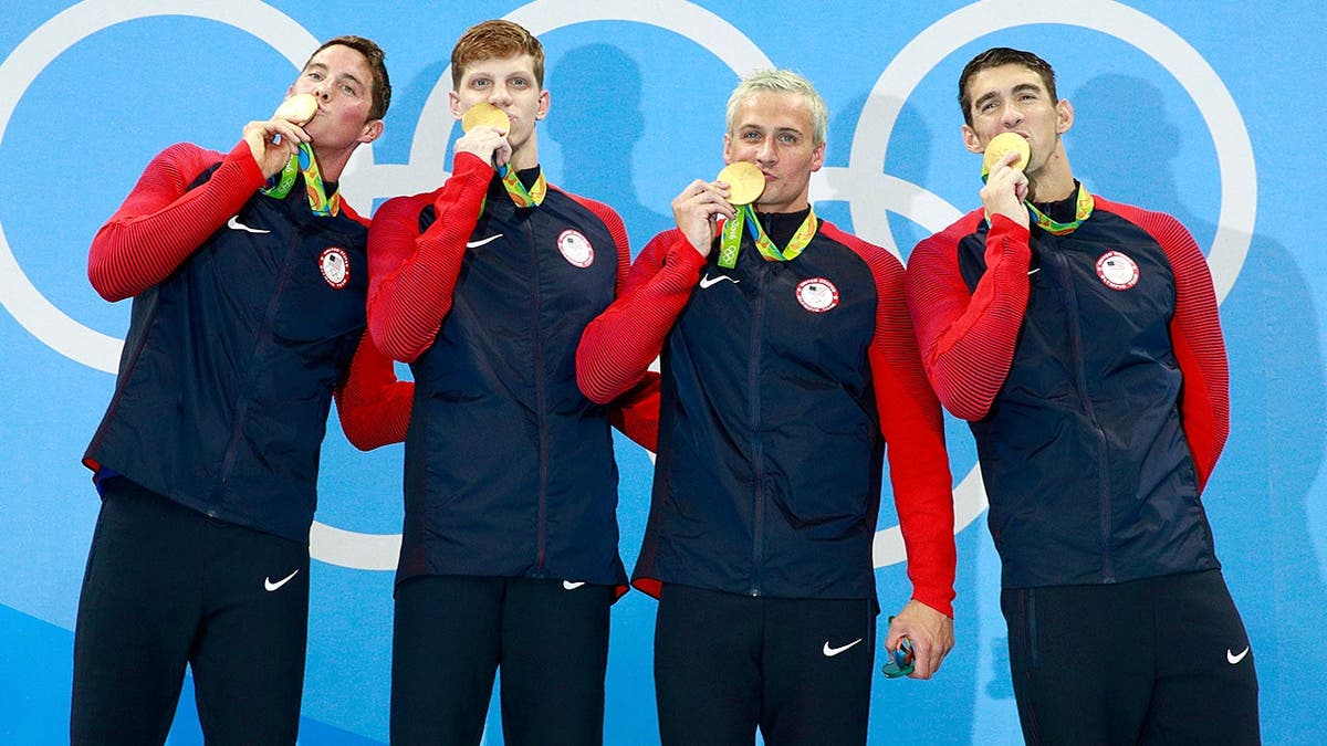 U.S. swimmers celebrate gold medal during Rio Olympics podium ceremony.