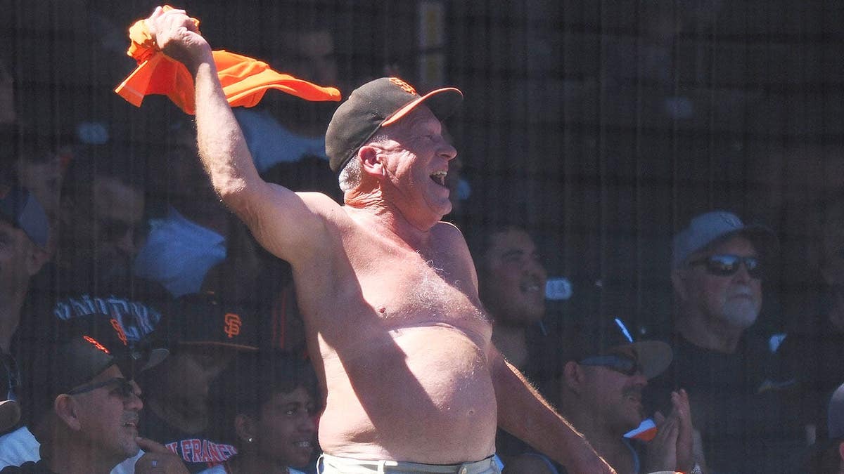 A San Francisco Giants fan waving his shirt at Oracle Park.