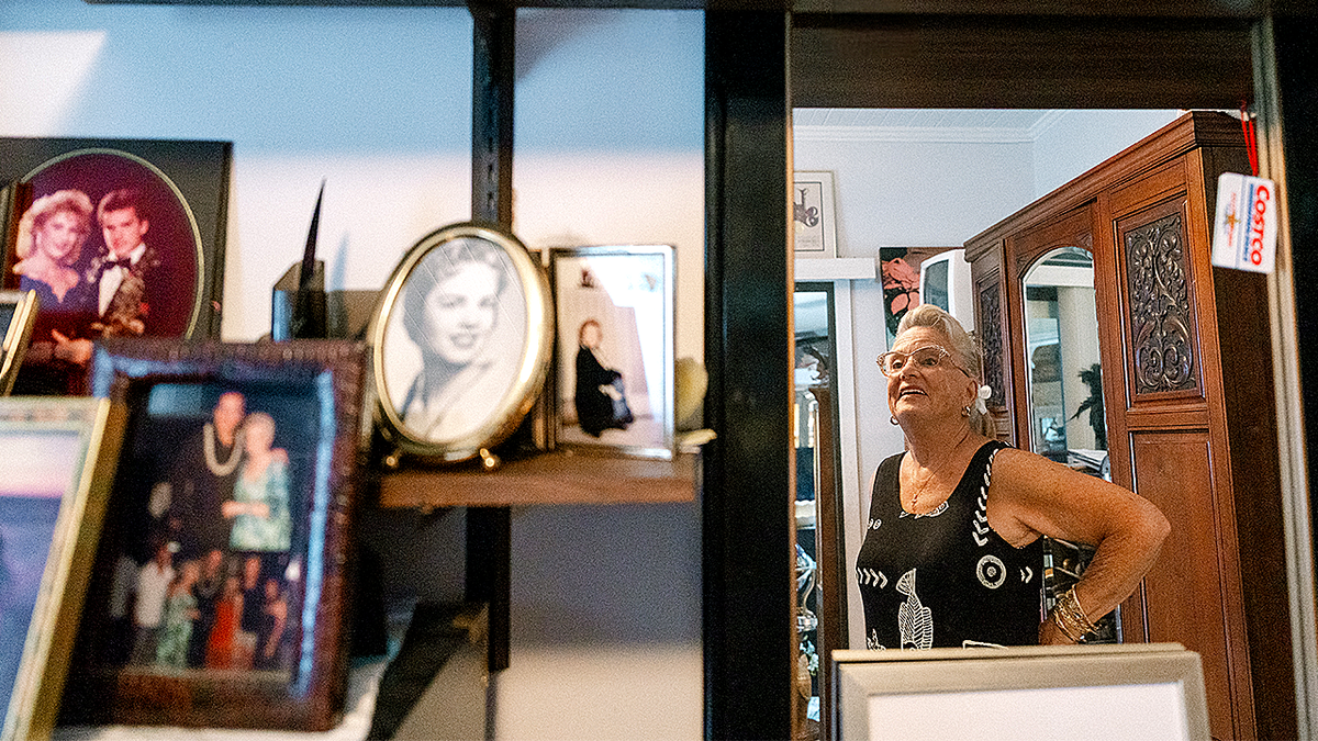 Sandra May smiling in home surrounded by family photos