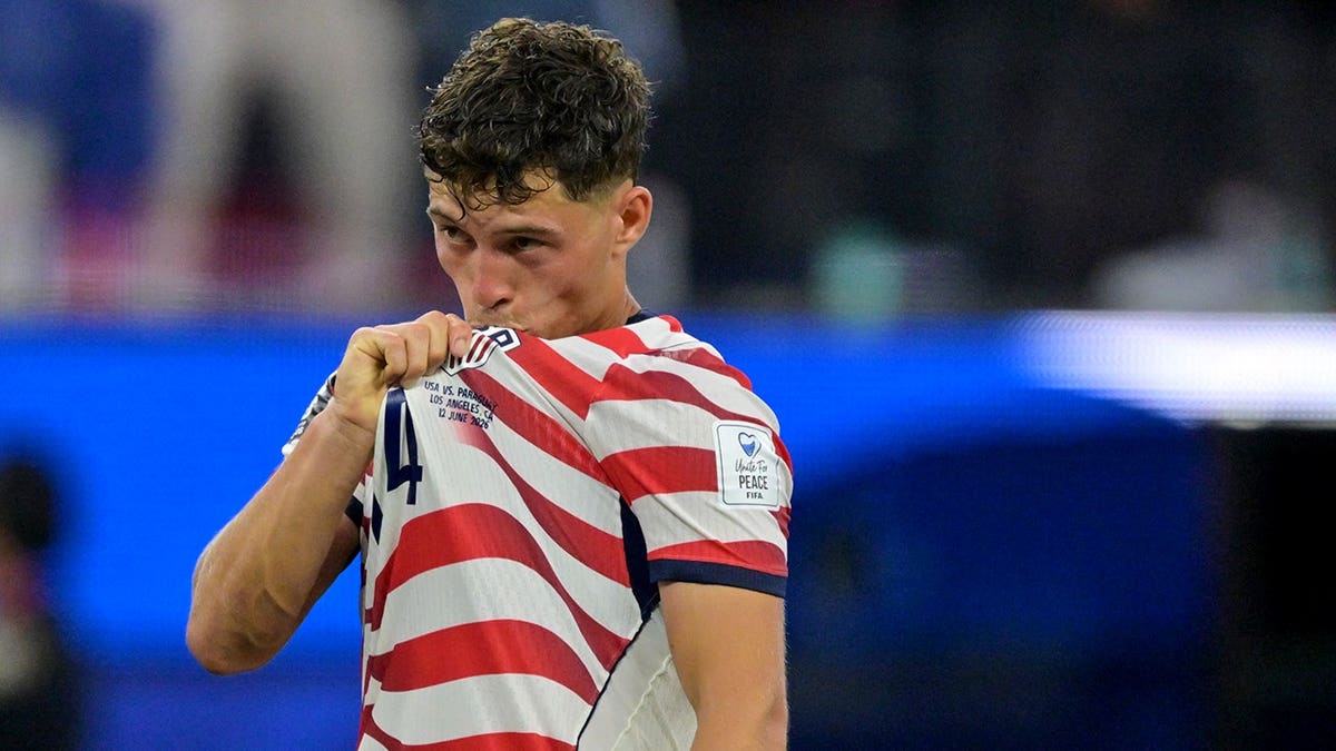 United States' Sebastian Berhalter kisses his jersey on the soccer field.