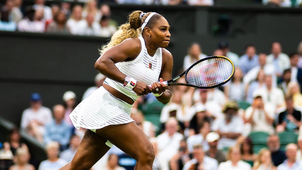 Serena Williams hitting a forehand during a tennis match at Wimbledon.