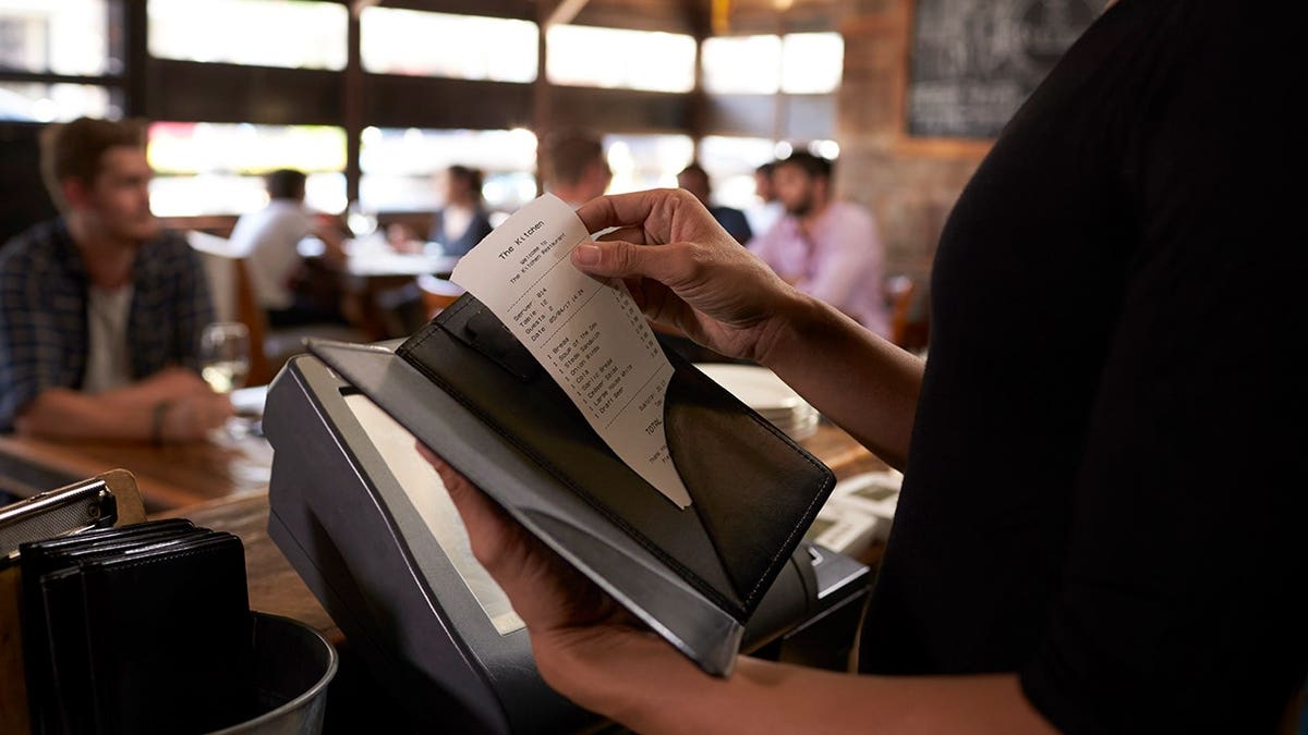 server preparing check at restaurant