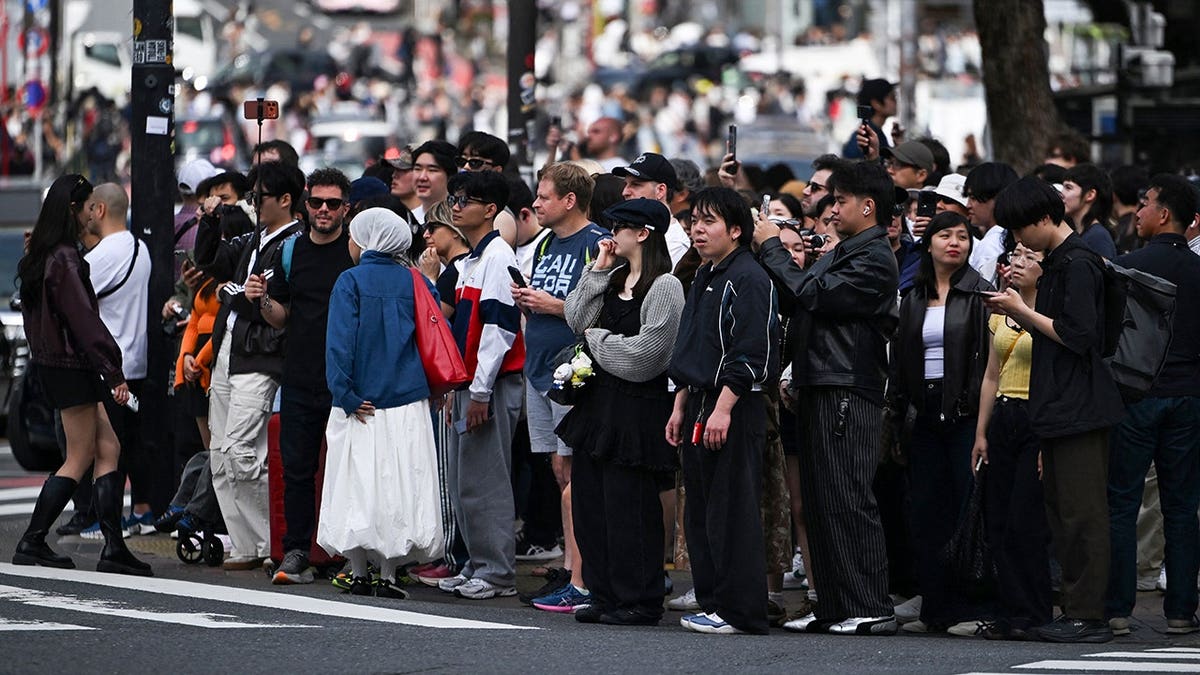 People waiting to cross Shibuya Crossing in Tokyo during a busy holiday period