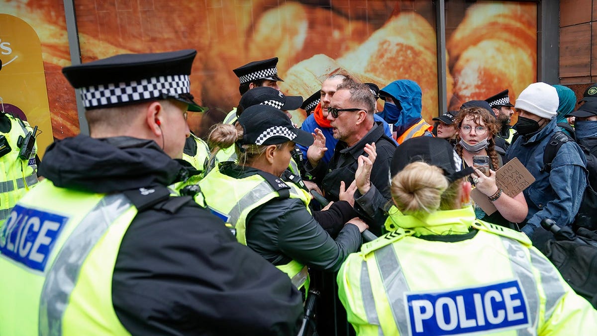 Manifestantes empurrando contra o cordão policial em Buchanan Steps, em Glasgow