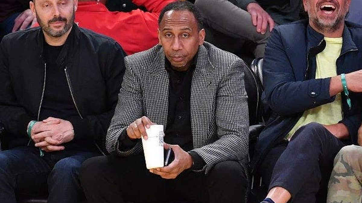 Stephen A. Smith standing courtside at a basketball game in Los Angeles