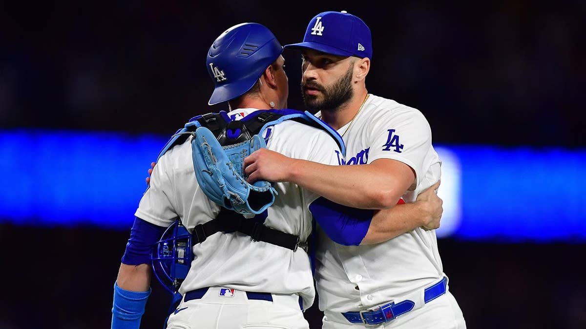 Los Angeles Dodgers pitcher Tanner Scott and catcher Will Smith celebrating on the field