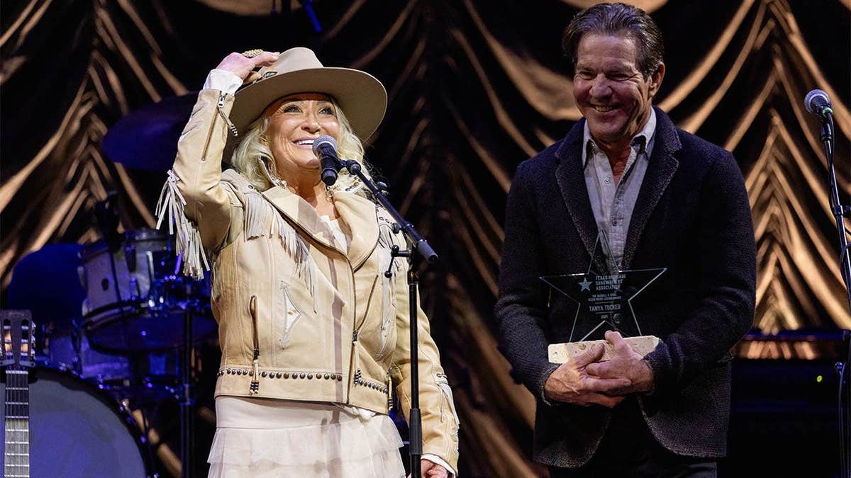 Singer-songwriter Tanya Tucker and Dennis Quaid speaking on stage at ACL Live in Austin, Texas.