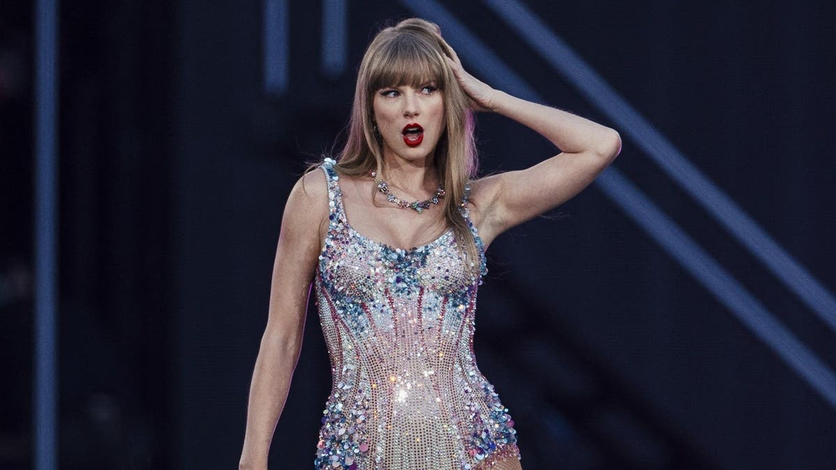 Taylor Swift singing on stage during her Eras Tour in Lisbon