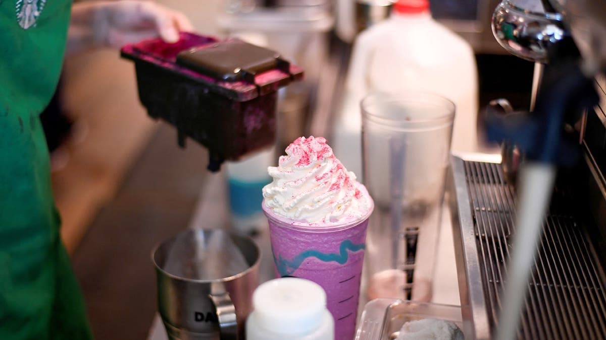 A barista makes a Unicorn Frappuccino at Starbucks.