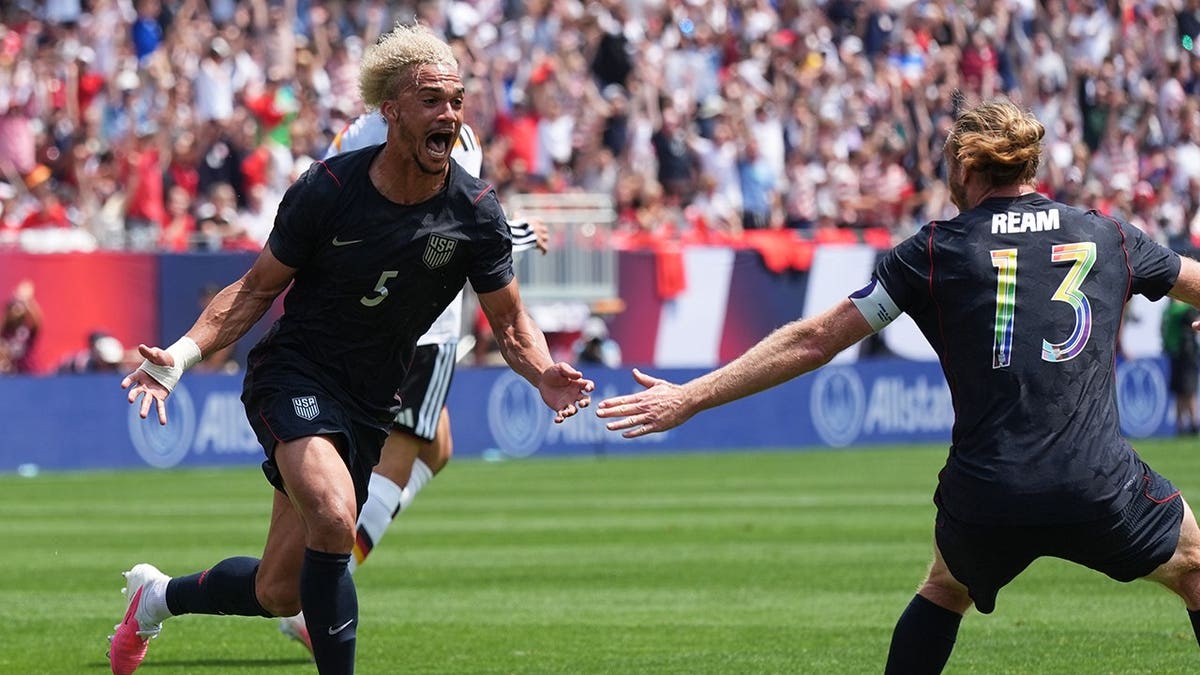 United States defenders Antonee Robinson and Tim Ream celebrating a goal during a soccer match in Chicago