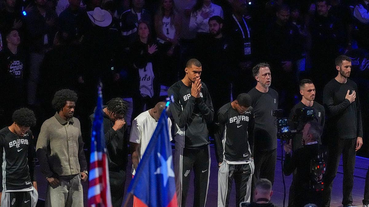 San Antonio Spurs forward Victor Wembanyama stands for the national anthem with his teammates at the Frost Bank Center
