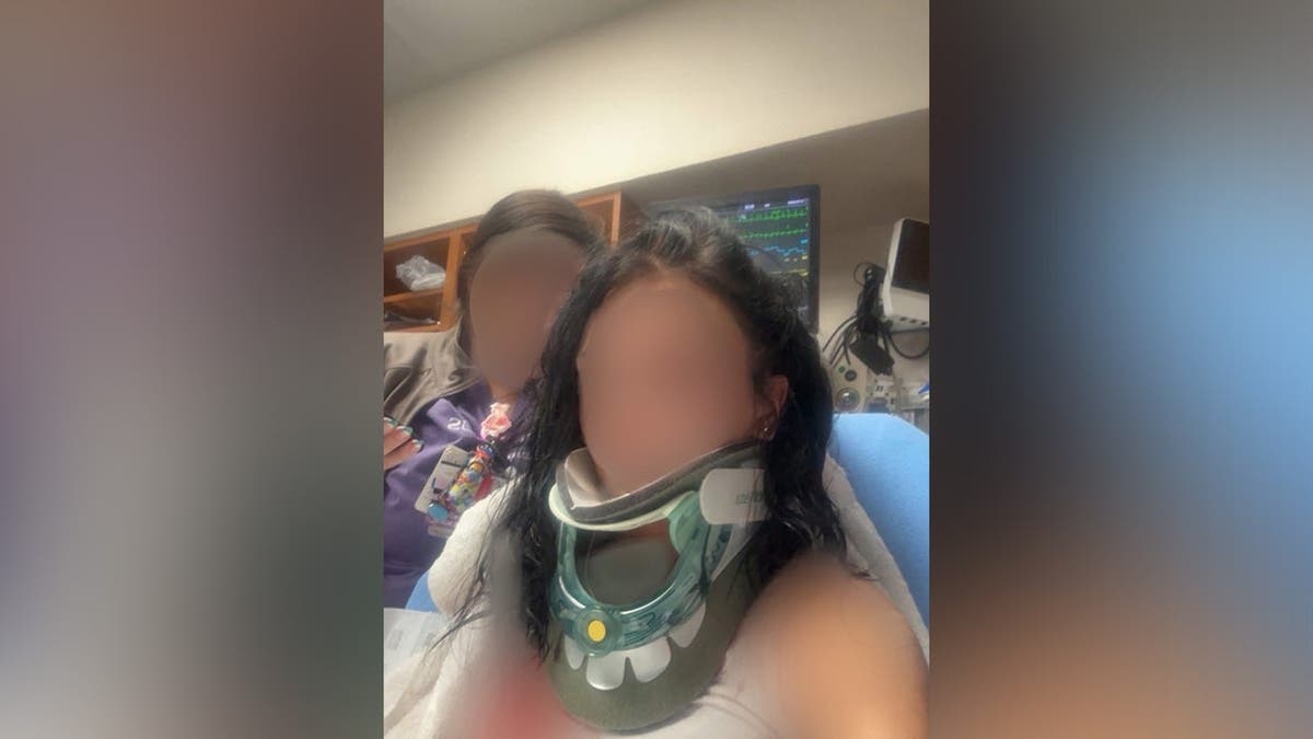 image shows blurred photo of a victim in a neck brace