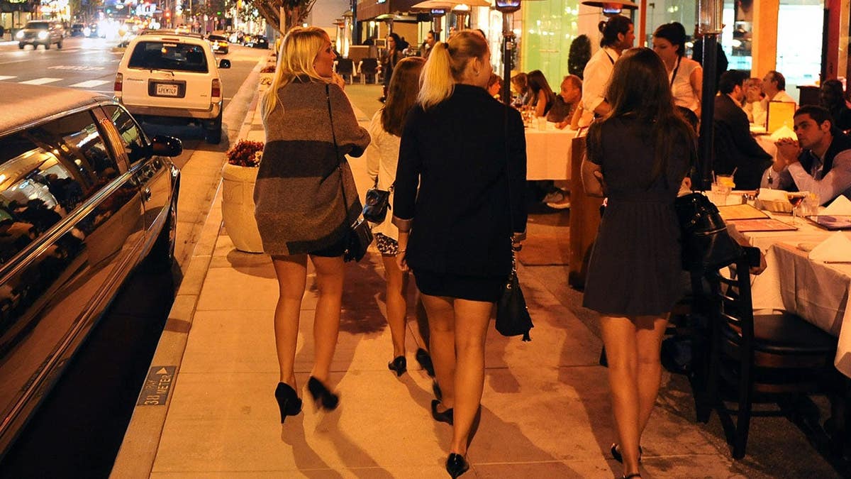 A group of women walking by a limo on Sunset Boulevard in West Hollywood