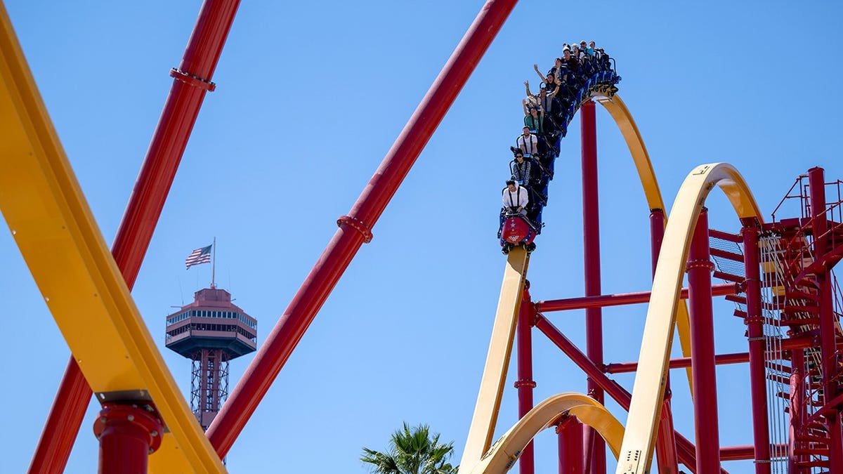 People riding Wonder Woman Flight of Courage roller coaster at Six Flags Magic Mountain in Valencia California
