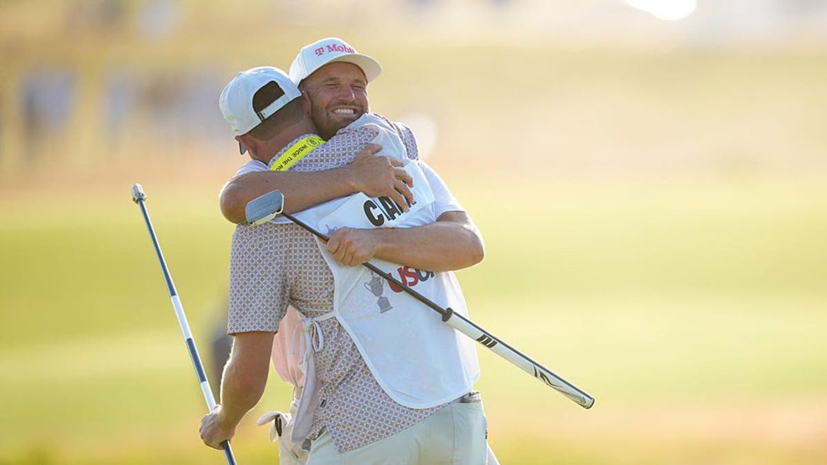 Wyndham Clark celebrates with his caddie
