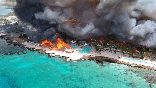 Flames billow from beachside buildings during a June 19, 2026, fire in the Dominican Republic resort town of Bayahibe.