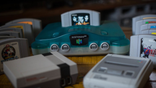 Nintendo 64 clear blue version with games next to Nintendo Classic Mini NES and Super Nintendo consoles
