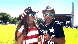GIF of couple in front of stage and Washington monument speaking to Fox reporters, dressed in American clothes