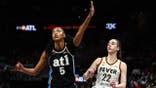 Caitlin Clark shooting a basketball against Angel Reese at State Farm Arena in Atlanta