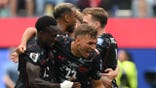 Canada's defenders Richie Laryea and Niko Sigur celebrating on the field at Los Angeles Stadium