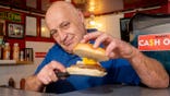 Christopher Higgitt standing at his £1 burger stand in Blackpool