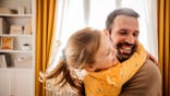 A dad sitting with his daughter enjoying time at home