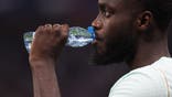 France's defender Dayot Upamecano drinks water on the field.