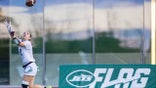 girl reaches up to catch a football