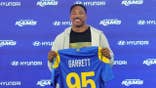 Myles Garrett of the Los Angeles Rams posing with his jersey at a press conference.