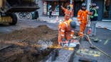 A construction crew working on an underground metal pipe in Brooklyn, New York City.