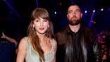 Taylor Swift and Travis Kelce standing together at the Dolby Theatre in Los Angeles