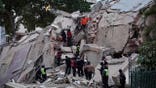 Rescuers search for victims in a collapsed building