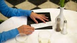 woman's hands over restaurant check