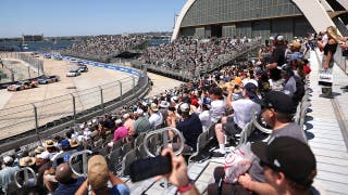 Un aficionado salta la valla durante NASCAR en la Base Naval de Coronado, en San Diego, en la que se había sacado la bandera roja, para conocer a un piloto