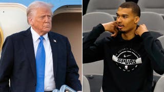 President Donald Trump reacts to Spurs star Victor Wembanyama folding his arms during the anthem