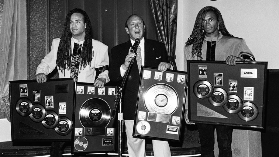 Milli Vanilli pose with Clive Davis