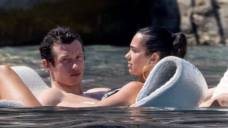 Dua Lipa and Callum Turner floating in the water while on their honeymoon.