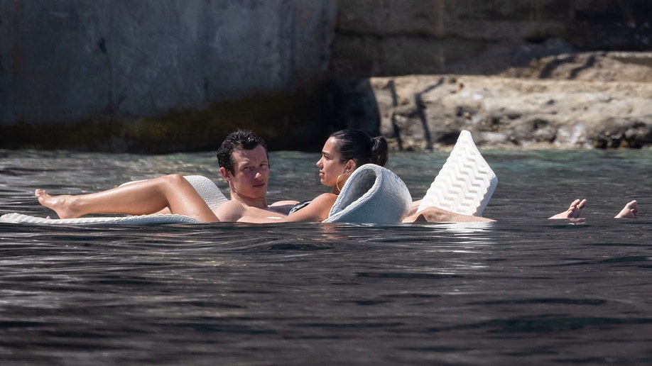 Dua Lipa and Callum Turner on floaties while on their honeymoon in Italy in June 2026.