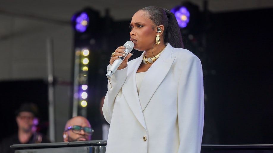 Jennifer Hudson holds a microphone and sings