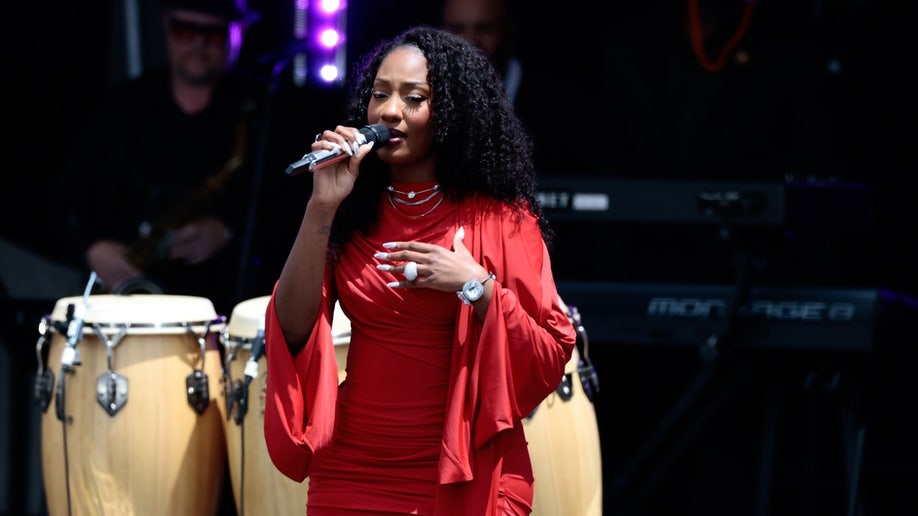 Tems holding a microphone at Obama's Presidential Center opening