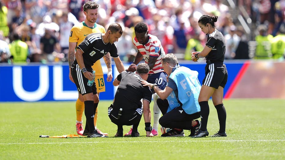 Folarin Balogun coaches referee through stretches after official cramps up during USA vs Australia match