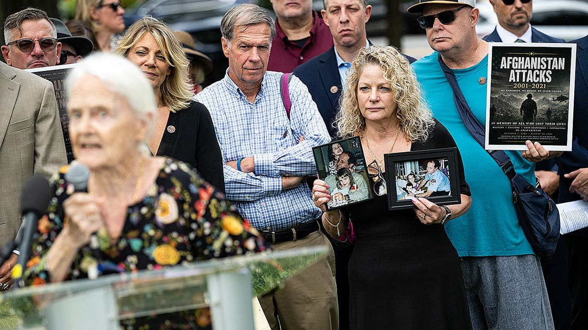 Janlyn Scauso holds family photos during a rally near the U.S. Capitol in Washington, D.C.
