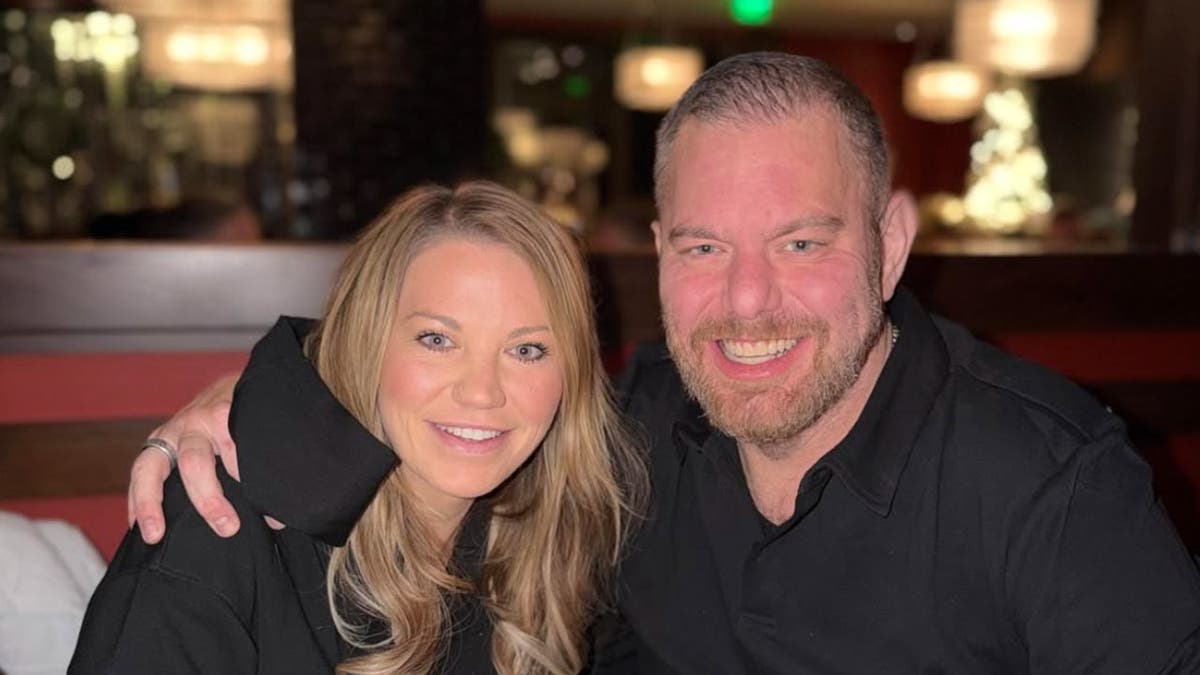 photo shows Alexandra with her husband at a table