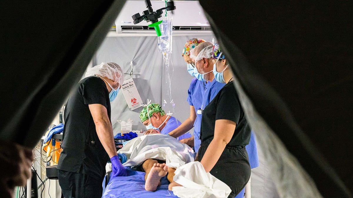 Doctors pray before performing surgery