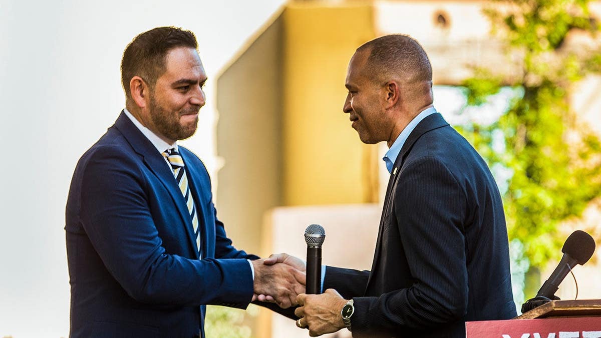 Hakeem Jeffries and Gabe Vasquez shake hands at a news conference.