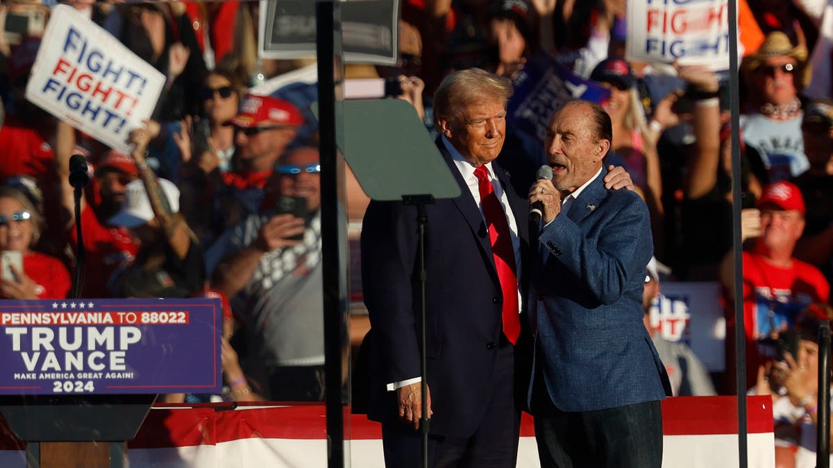 BUTLER, PENNSYLVANIA - OCTOBER 05: Performer Lee Greenwood sings as Republican presidential nominee, former President Donald Trump takes the stage during a campaign rally at the Butler Farm Show grounds on October 05, 2024 in Butler, Pennsylvania. This is the first time that Trump has returned to Butler since he was injured during an attempted assassination on July 13. (Photo by Kevin Dietsch/Getty Images)