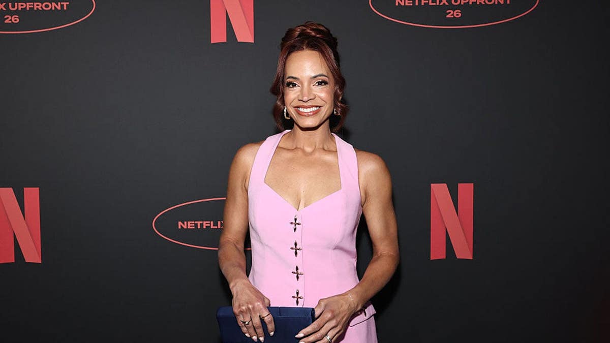 Elle Duncan stands at an event backdrop.